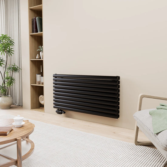 Schwarzer horizontaler Design-Heizkörper an der Wand in einem modernen Wohnzimmer