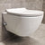 Weißes wandhängendes Dusch-WC mit geöffnetem Deckel und integrierter Bidet-Düse